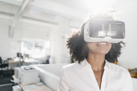 Frau mit VR-Brille im Büro, lizenzfreies Stockfoto