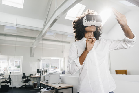 Frau mit VR-Brille im Büro, lizenzfreies Stockfoto