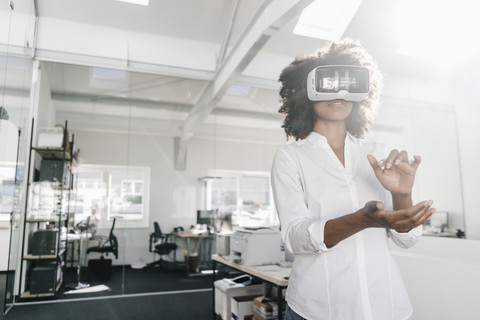 Frau mit VR-Brille im Büro, lizenzfreies Stockfoto