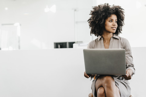 Young woman using laptop in office stock photo