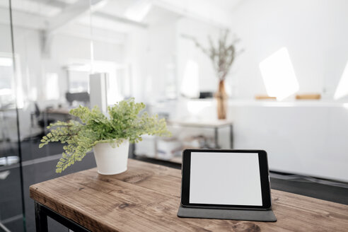 Tablet auf Holztisch im Büro - KNSF02344