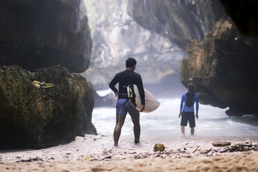 Indonesien, Bali, Rückenansicht eines Surfers mit Surfbrett - KNTF00867