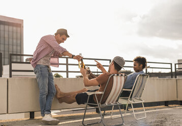 Three friends having a rooftop party - UUF11451