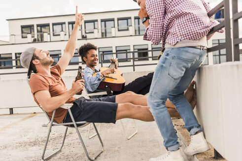 Drei Freunde feiern eine Dachterrassenparty - UUF11452