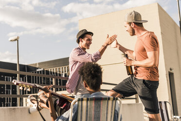 Drei Freunde feiern eine Dachterrassenparty - UUF11459