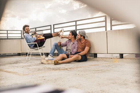 Three friends having a rooftop party - UUF11460