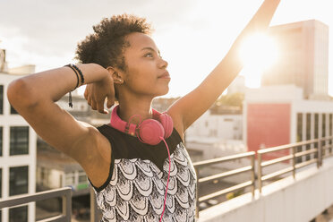 Young woman with headphones on rooftop - UUF11494