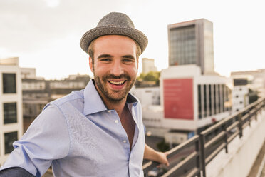 Portrait of happy young man on rooftop - UUF11509