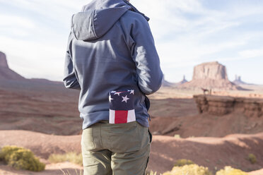 USA, Utah, Rückenansicht eines jungen Mannes mit gefalteter amerikanischer Flagge in seiner Tasche im Monument Valley - EPF00456