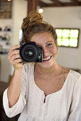 Porträt einer lachenden jungen Frau, die ein Bild mit einer Kamera aufnimmt - ECPF00051