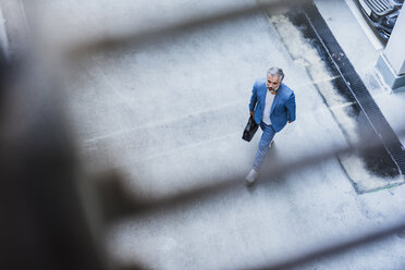 Businessman walking holding bag - DIGF02652