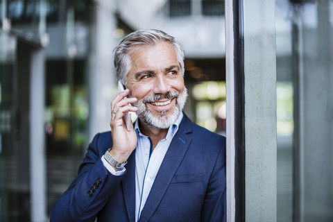 Smiling businessman on cell phone stock photo