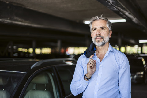 Portrait of businessman in parking garage stock photo