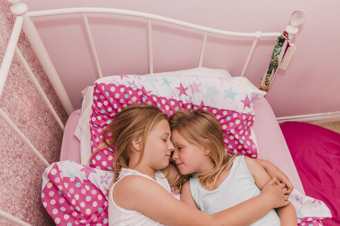 Zwei kleine Schwestern ruhen sich auf dem Bett aus - NMSF00139