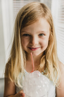 Porträt eines blonden kleinen Mädchens, das Milchblasen bläst - NMSF00140