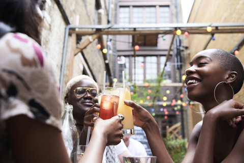 Drei Freunde stoßen mit Cocktails an, lizenzfreies Stockfoto