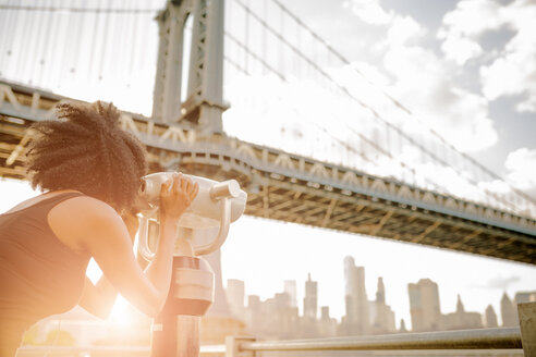 USA, New York City, Brooklyn, Frau schaut durch ein münzbetriebenes Fernglas auf die Manhattan Bridge - GIOF03093