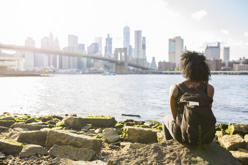 USA, New York City, Brooklyn, Frau sitzt am Wasser - GIOF03096