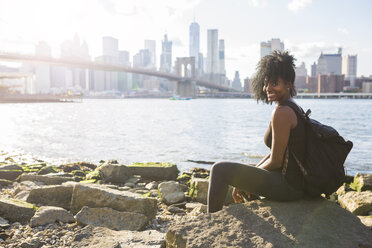 USA, New York City, Brooklyn, Porträt einer lächelnden Frau, die am Wasser sitzt - GIOF03097