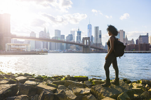 USA, New York City, Brooklyn, woman standing at the waterfront - GIOF03098