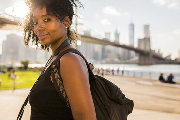 USA, New York City, Brooklyn, portrait of smiling woman at the waterfront - GIOF03108