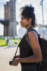 USA, New York City, Brooklyn, woman with camera at Brooklyn Bridge - GIOF03109