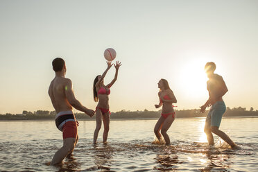 Glückliche Freunde spielen mit einem Ball im Wasser - VPIF00013