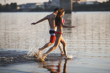 Happy couple running in water - VPIF00017