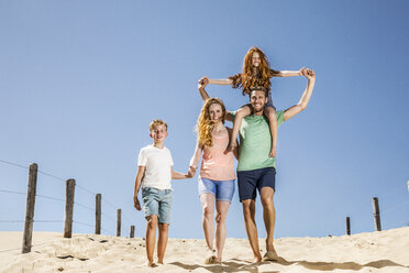 Niederlande, Zandvoort, glückliche Familie beim Spaziergang am Strand - FMKF04310