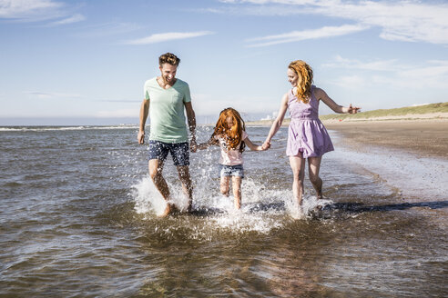 Niederlande, Zandvoort, glückliche Familie beim Planschen im Meer - FMKF04312