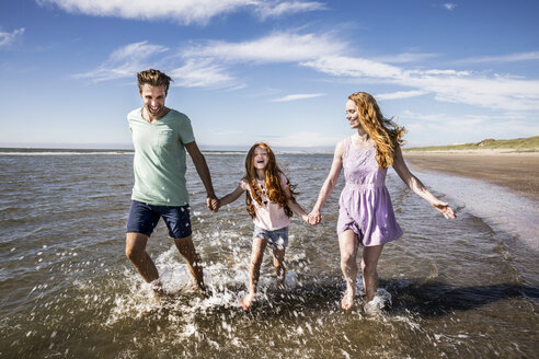 Niederlande, Zandvoort, glückliche Familie beim Planschen im Meer - FMKF04313
