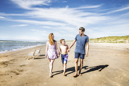 Niederlande, Zandvoort, glückliche Familie beim Spaziergang am Strand - FMKF04314