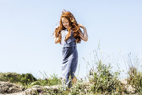 Niederlande, Zandvoort, rothaariges Mädchen spaziert in den Dünen - FMKF04336