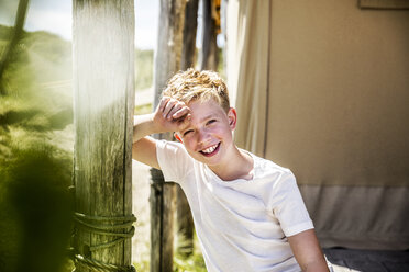 Porträt eines glücklichen Jungen auf dem Campingplatz - FMKF04340