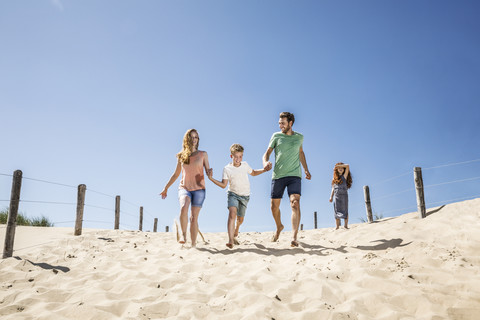 Niederlande, Zandvoort, glückliche Familie beim Laufen am Strand, lizenzfreies Stockfoto