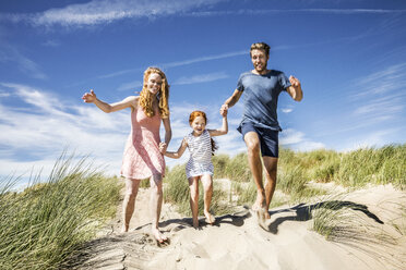 Niederlande, Zandvoort, glückliche Familie mit Tochter läuft in den Stranddünen - FMKF04361