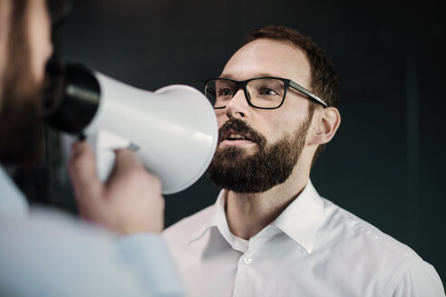 Manager mit Megaphon gibt Geschäftsleuten Anweisungen - JOSF01333