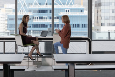 Businesswoman talking to colleague in modern office - ZEF14298