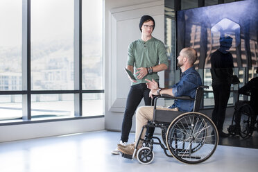 Man talking to handicapped colleague in wheelchair - ZEF14313