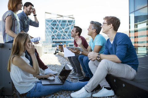 Geschäftsleute bei einem zwanglosen Treffen auf einer Dachterrasse, lizenzfreies Stockfoto