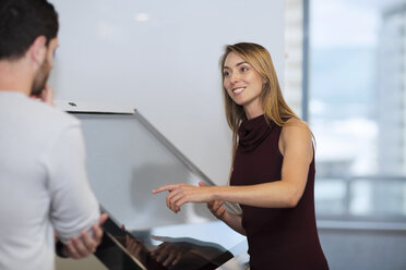 Businesswoman with colleague standing by control screen - ZEF14354