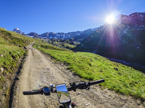 Italien, Lombardei, Cevedale Vioz Bergkamm, Handy auf dem E-Bike, lizenzfreies Stockfoto