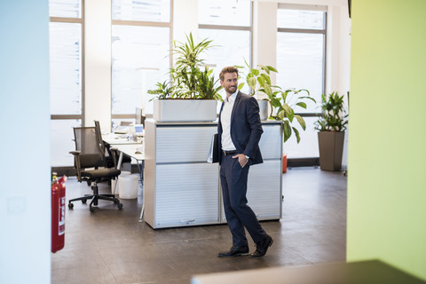 Geschäftsmann mit Akten im Büro, lizenzfreies Stockfoto