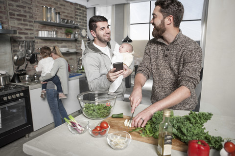 Familie und Freunde bereiten in der Küche eine gesunde Mahlzeit zu, lizenzfreies Stockfoto