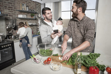 Family and friends preparing a healthy meal in kitchen - ZEF14411