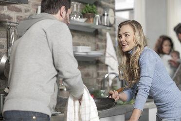Couple discussing in kitchen while preparing a meal - ZEF14419