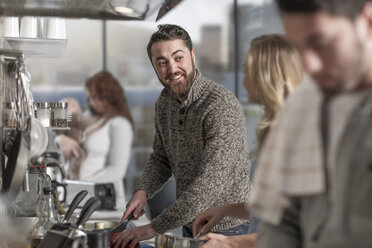 Familie und Freunde bei der Zubereitung einer Mahlzeit in der Küche - ZEF14457