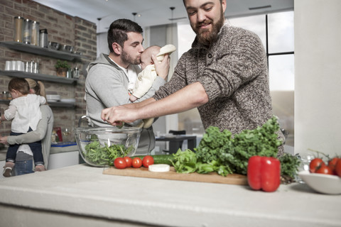 Family and friends preparing a healthy meal in kitchen stock photo