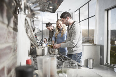 Friends preparing meal in kitchen - ZEF14486