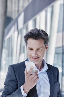 Portrait of smiling businessman using cell phone - RORF00985